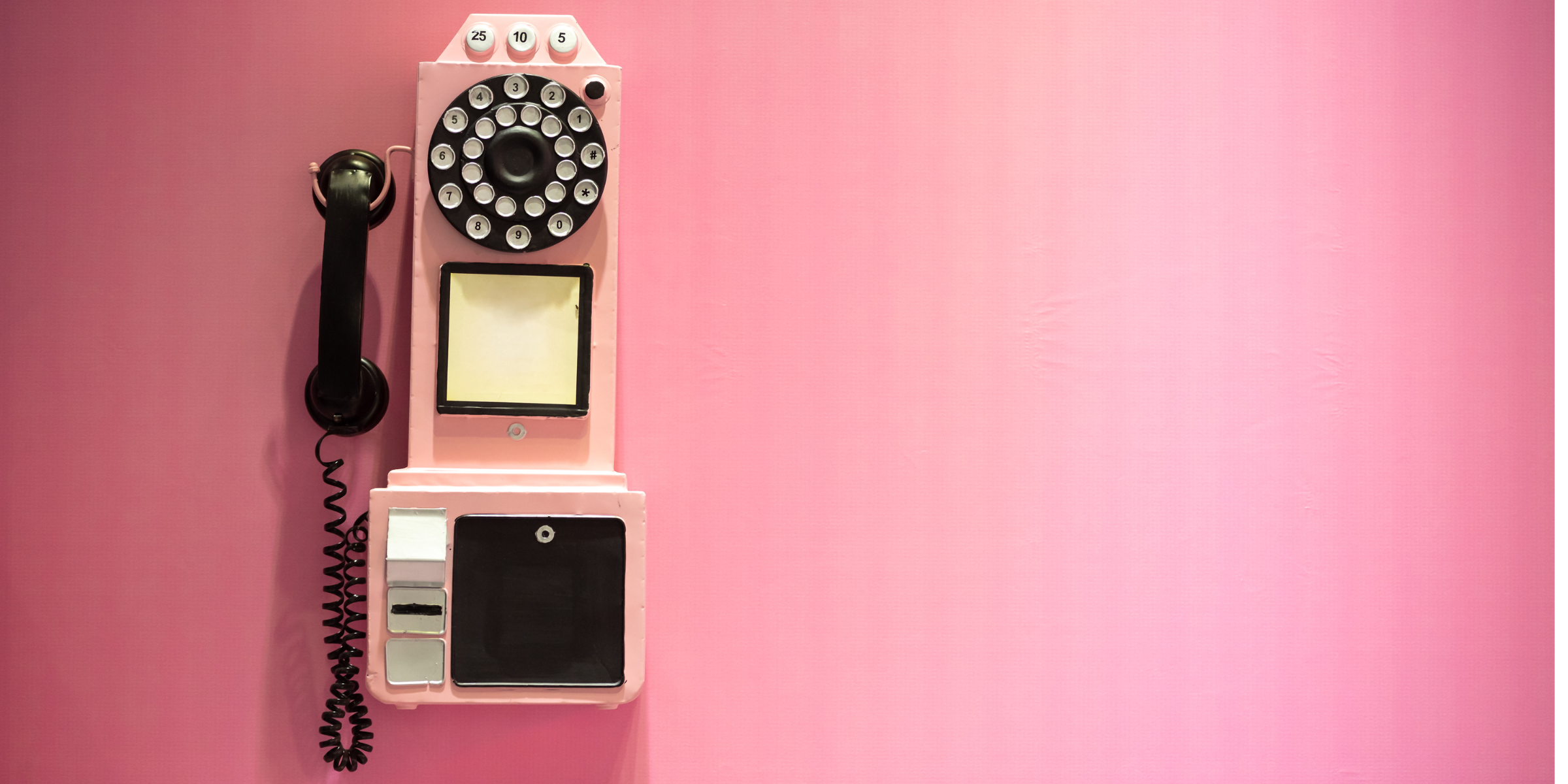 A pink wall phone on a pink background, for a blogpost detailing the benefits of switching to an virtual medical receptionist software