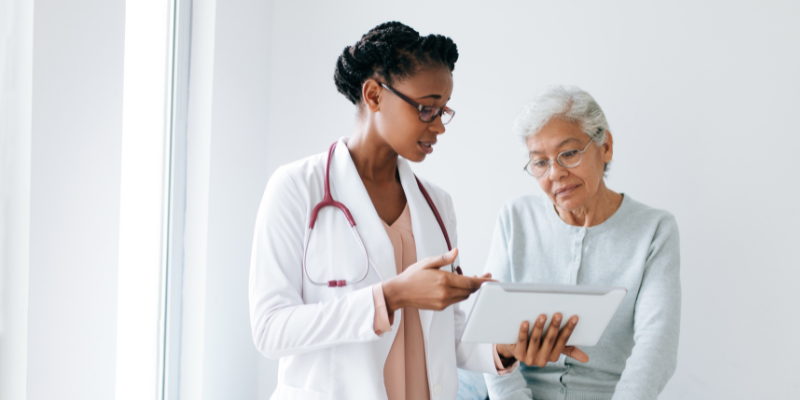 Provider communicating with patient about data on a tablet.