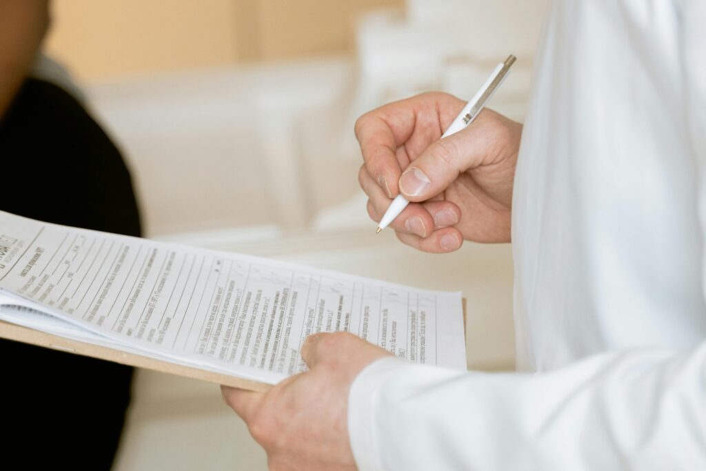 Patient and doctor filling out a patient intake form on a clipboard